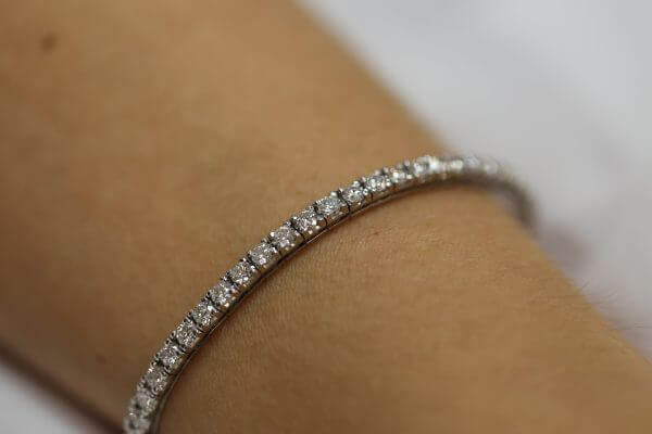 A woman's wrist adorned with a Claw set diamond tennis bracelet C926.