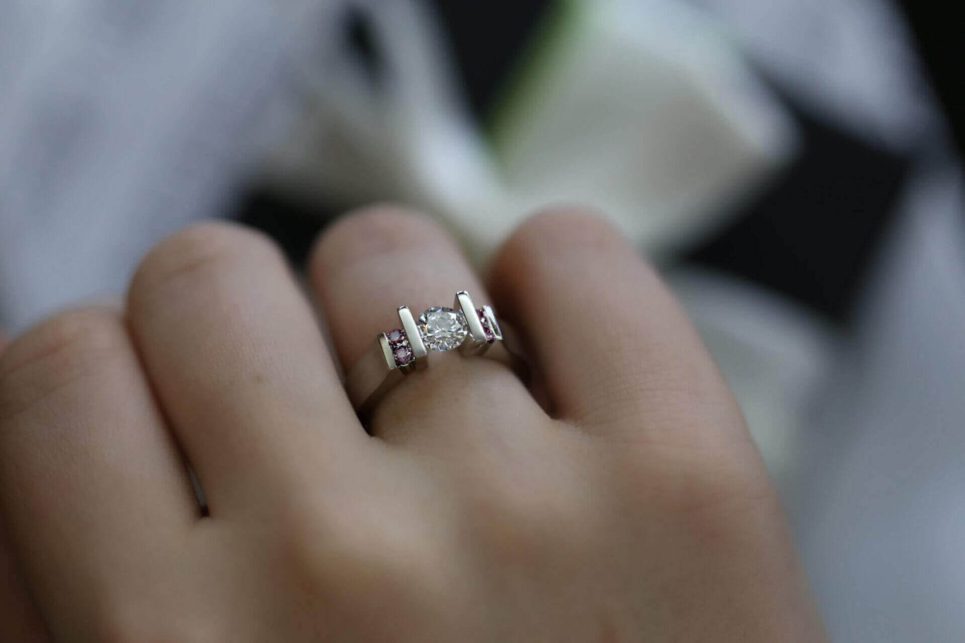 A woman's hand showcasing a stunning Tension Set White & Pink Diamond Ring C950.