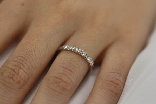 A woman's hand adorned with a stunning White and Pink Diamond Wedding Ring C573.