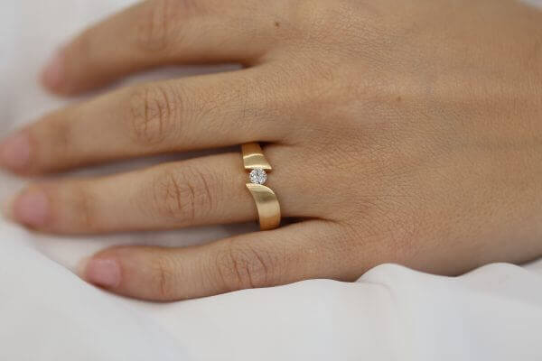 A woman wearing a Yellow Gold Flat Tension Set Round Diamond Ring C745.