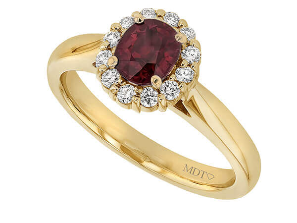 An elegant Oval Ruby Engagement Ring with Diamond Halo C1215 with a stunning oval ruby stone surrounded by a diamond halo.