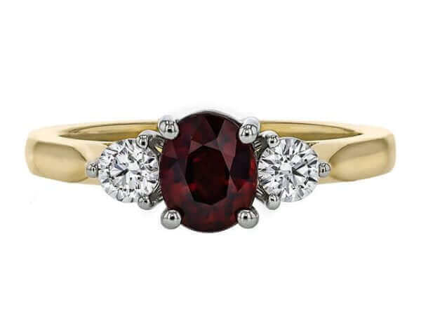 Gold ring with red gemstone and diamonds.